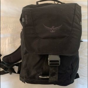 Black Osprey knapsack with orange interior.